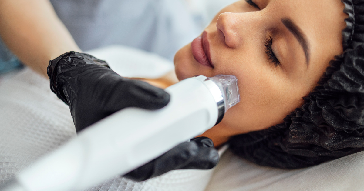 Woman receiving Morpheus8 treatment in Fredericksburg, VA, from a professional using a device on her cheek for skin tightening and rejuvenation.
